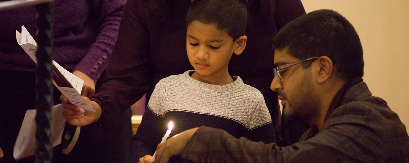 Child lighting a candle on the first Sunday in Advent