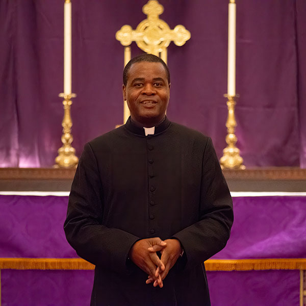 Fr George Kwari in front of the altar arrayed in purple for Advent