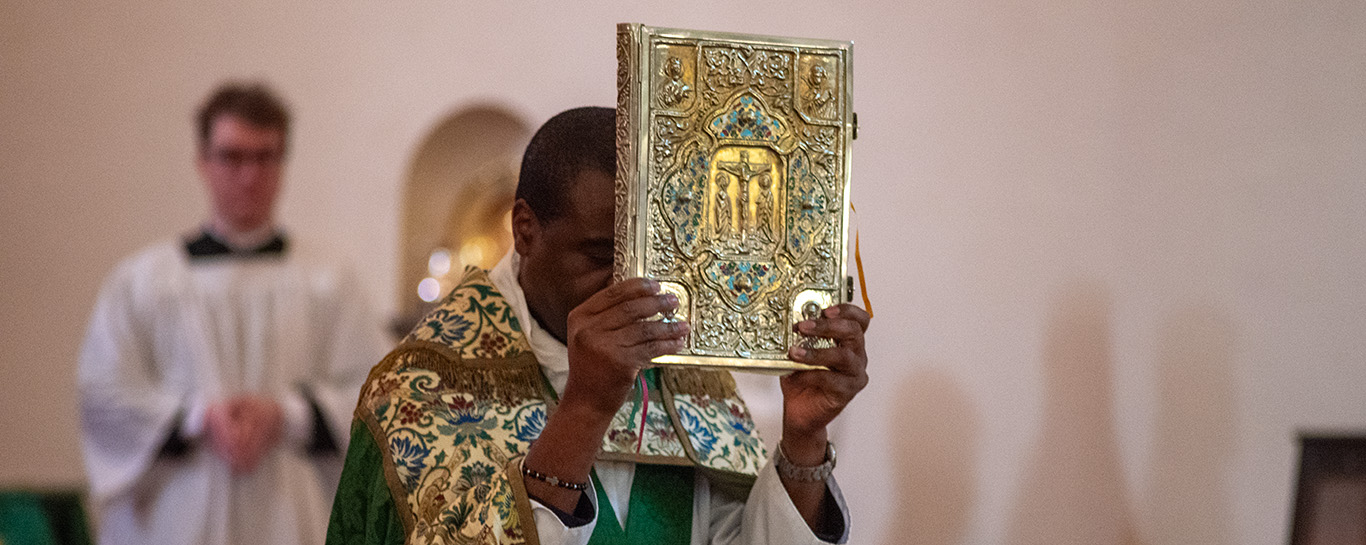 Fr George carryng the Gospel book in procession before the Gospel reading. 
