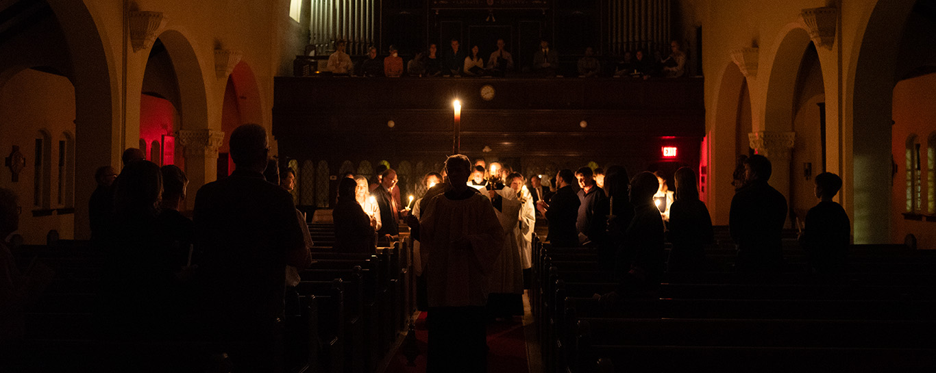 Christ candle procession with the church in darkness
