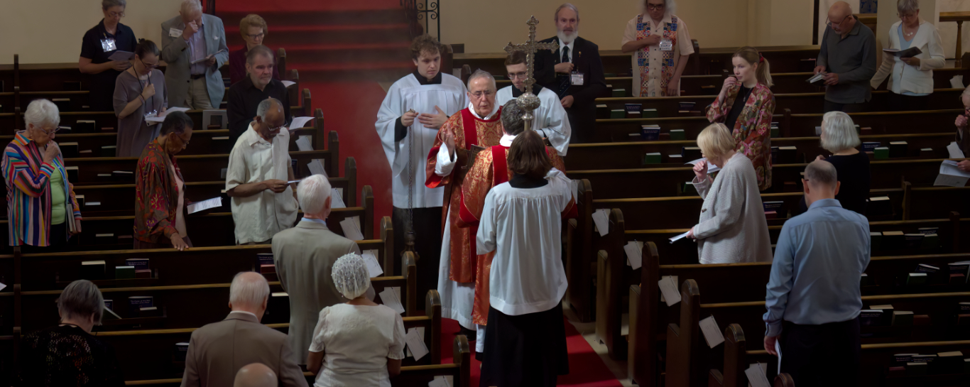 Fr Tudin reads the gospel during the feast of the Holy Cross. 